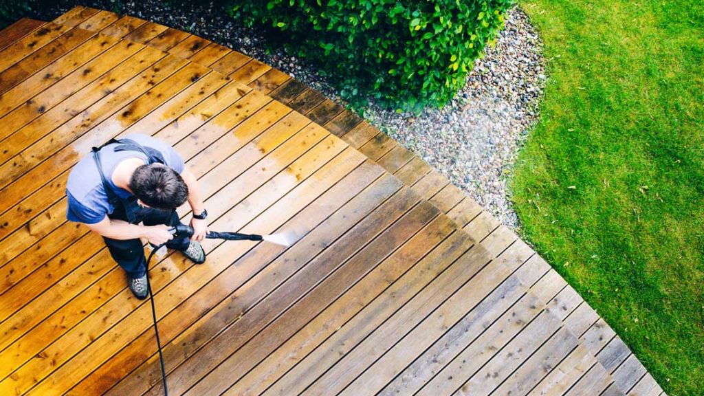 Man Cleaning Terrace With A Pressure Washer